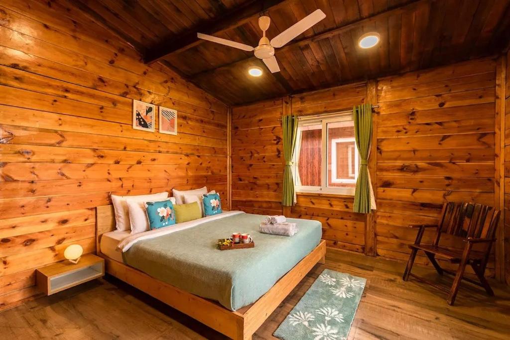 a bedroom with a bed in a log cabin at Aveeno Resort with Swimming Pool Near Calangute & Baga in Goa