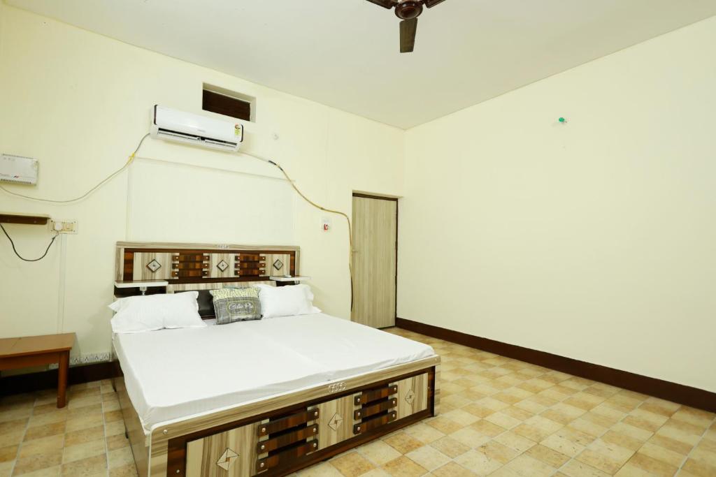 Cette chambre est dotée d'un lit avec un sidx blanc. dans l'établissement 2 Room and Kitchen Furnished Set-up Near Benaras Railway Station, à Varanasi