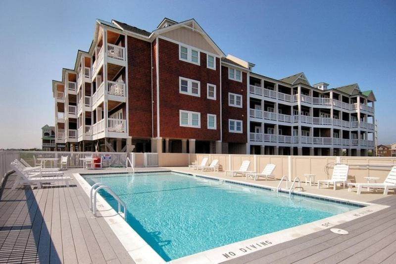 un gran edificio de apartamentos con piscina al lado de un edificio en LSC201-Gracens Sweet Retreat1 Min Drive to Beach, en Nags Head