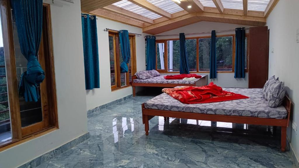 two beds sitting in a room with windows at Shiv Shakti B & B in Shimla