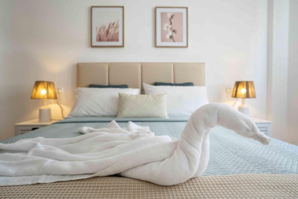 um cisne branco feito de toalhas numa cama em Prada Suite Home em Córdoba