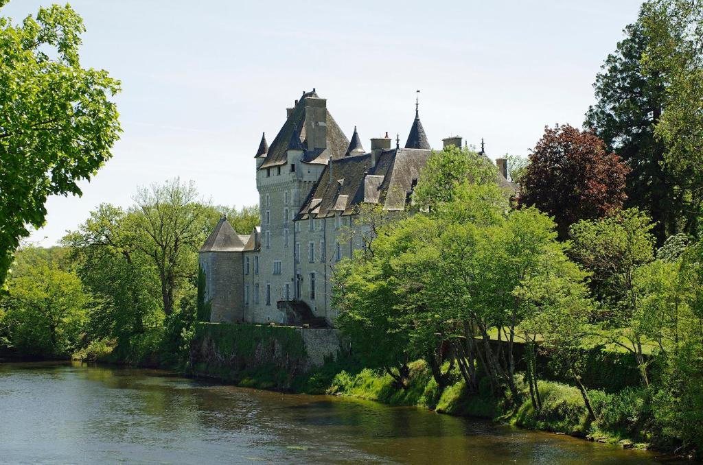 un viejo castillo sentado al lado de un río en Château de La Tour en Brenne, en Rivarennes