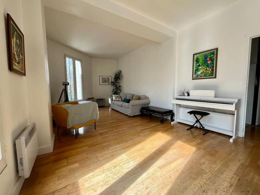 - un salon avec un piano et un canapé dans l'établissement Bienvenue, à Montrouge