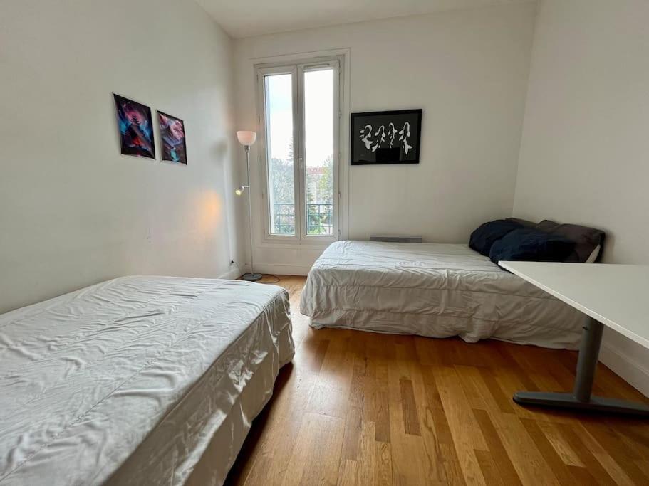 a bedroom with two beds and a window at Bienvenue in Montrouge