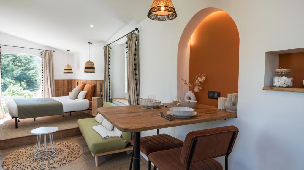a living room with a table and a bedroom at Le Pavillon - Les Lodges de Praly in Les Ollières-sur-Eyrieux
