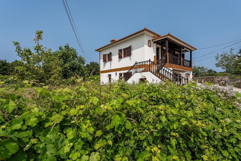 una casa en la cima de una colina con arbustos en GuestReady - Rustic Oasis in Vila Nova de Cerveira, en Vila Nova de Cerveira