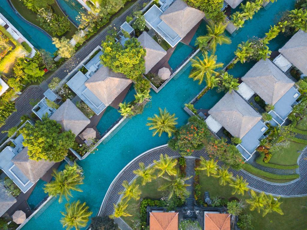 an aerial view of a resort with palm trees and water at MERUSAKA Nusa Dua in Nusa Dua