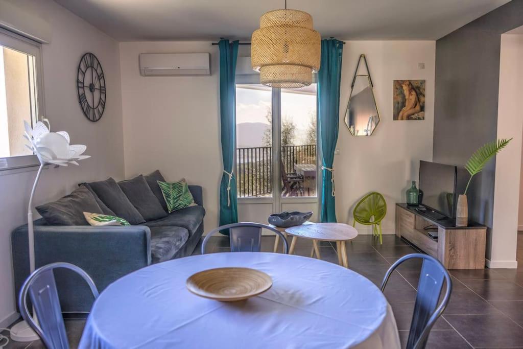 un salon avec une table et un canapé dans l'établissement Appartement F4 neuf avec jardin et cuisine d'été, à Olmeto