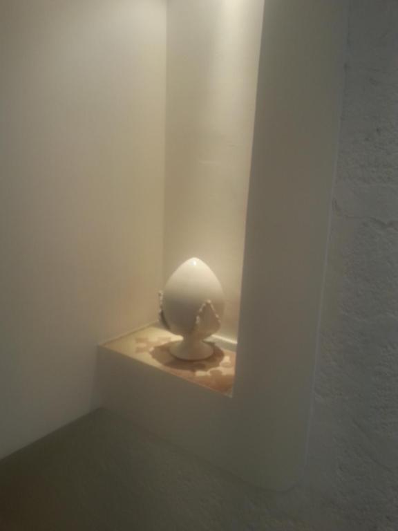 Una habitación blanca con una estatua en una pared. en Casa Ginevra, en Monopoli