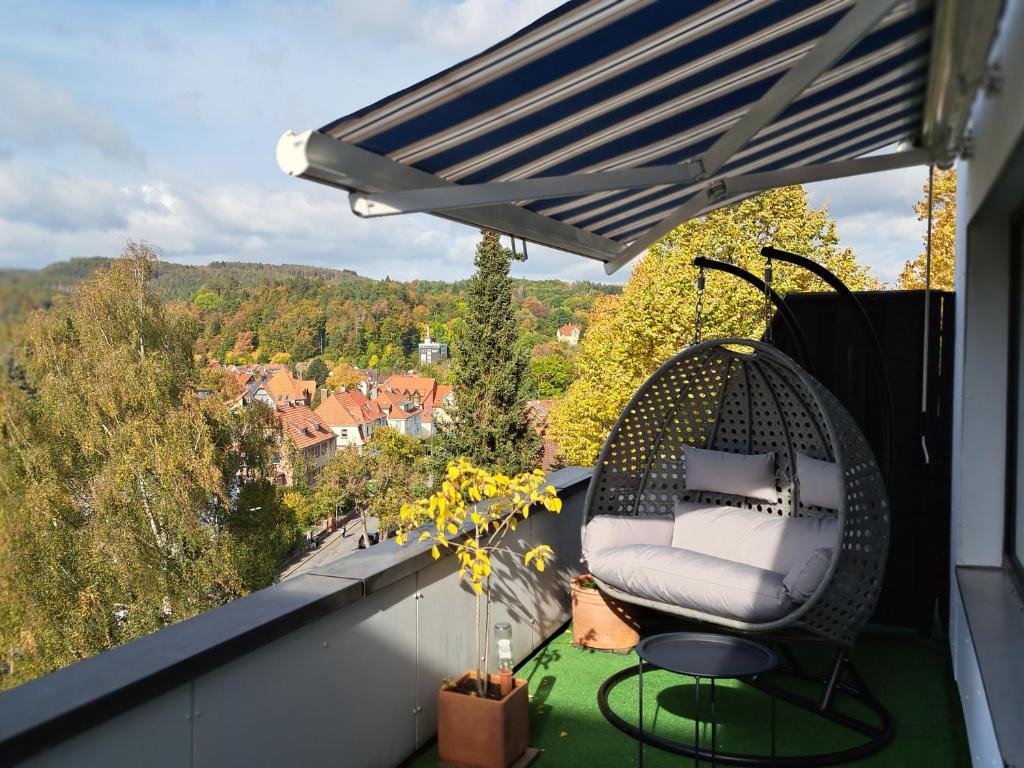 a chair sitting on a balcony with a view at Das kleine Penthouse mit Kamin in Bad Sachsa