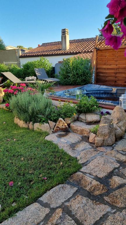 un patio trasero con un jardín de rocas con piscina en Betty vacanze, en Badesi