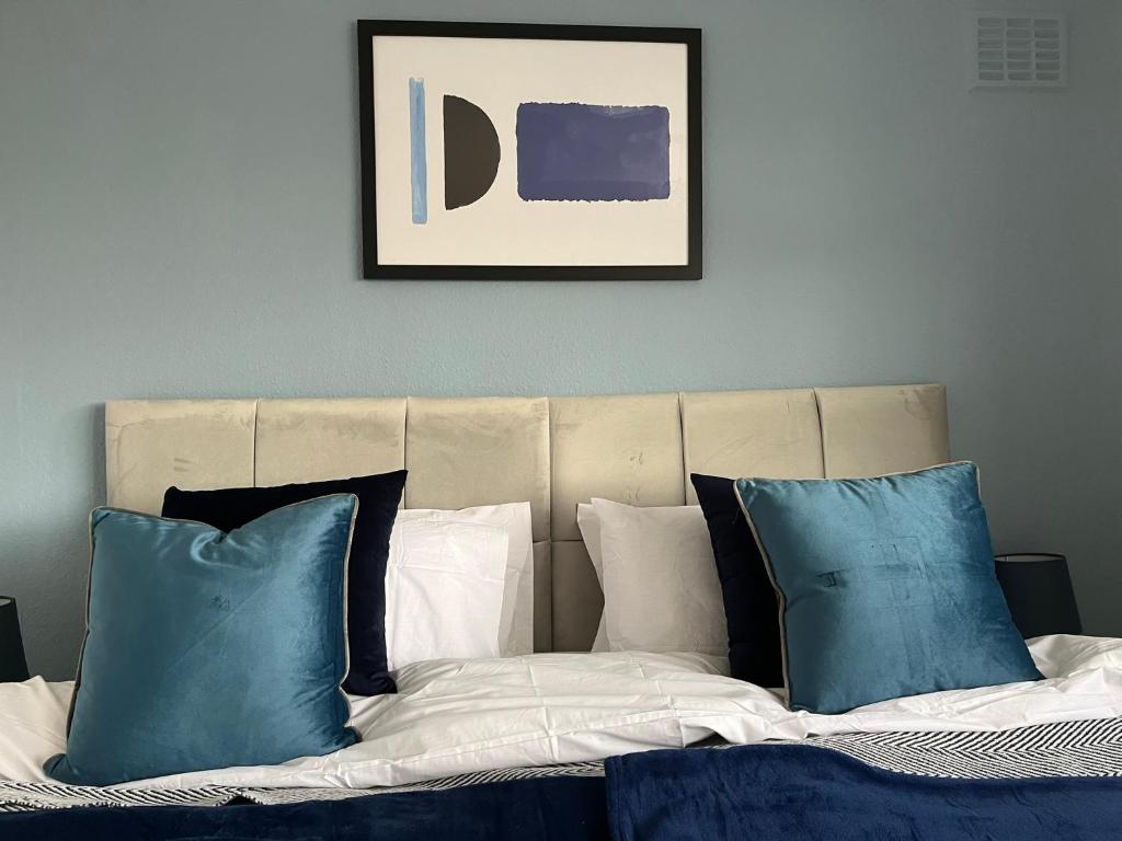 1 cama con almohadas azules y blancas en una habitación en Harrowby Home, en Lincolnshire