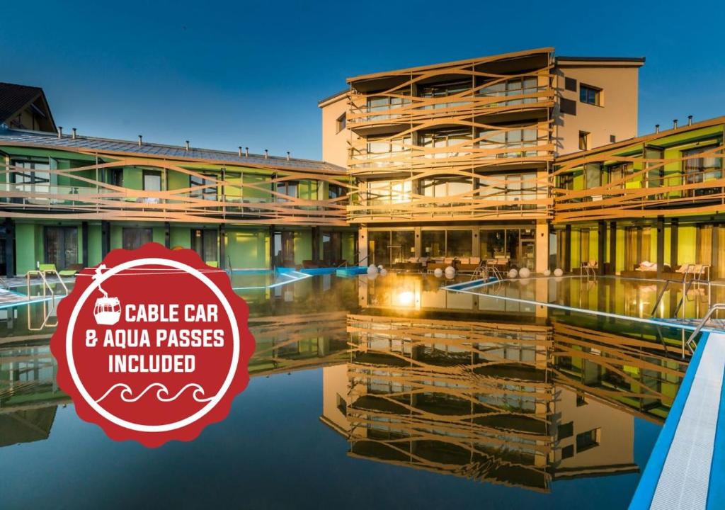 a building with a red circle car and aanu phrases included at Hotel Galeria Thermal Bešeňová in Bešeňová