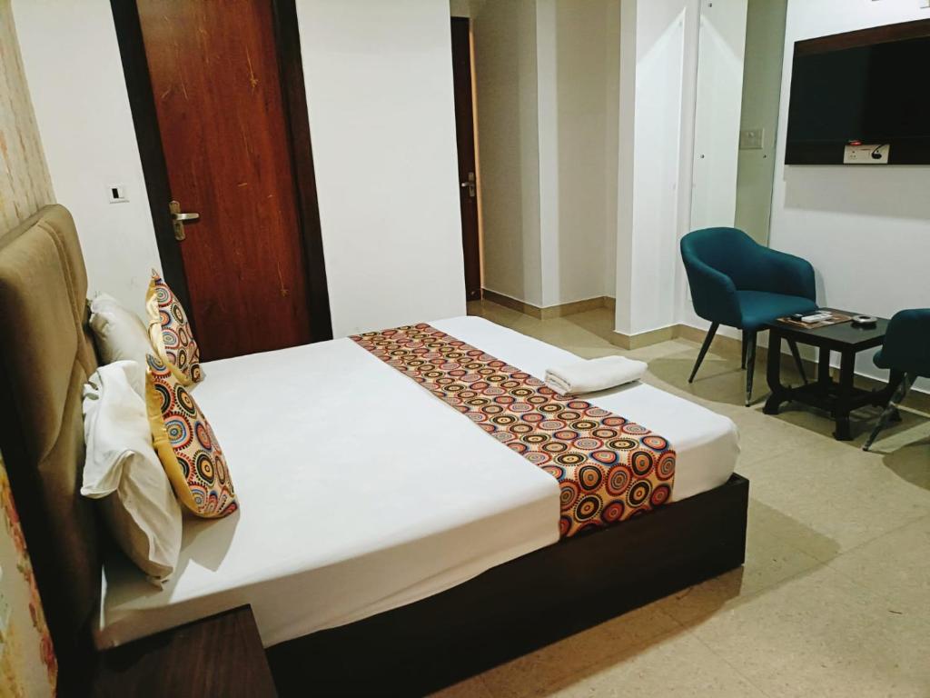 a hotel room with a bed and a chair at Airport Hotel IVY in New Delhi