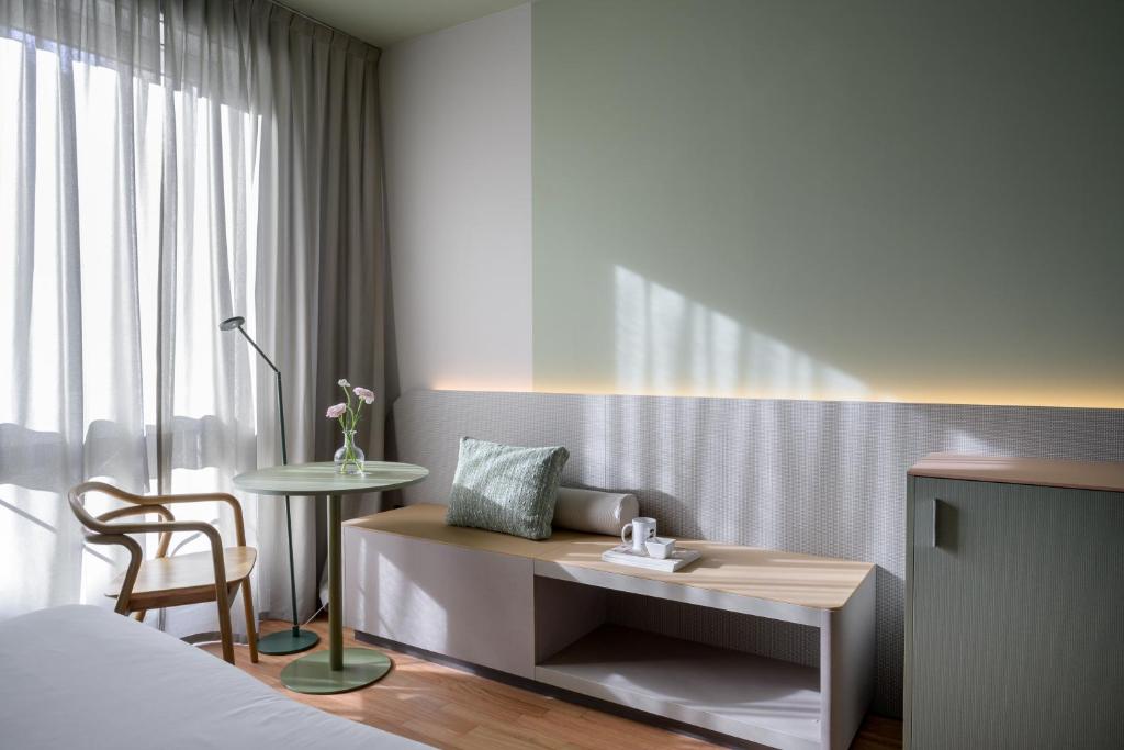 ein Schlafzimmer mit einem Bett, einem Tisch und einem Stuhl in der Unterkunft Hotel Ilaria in Lucca