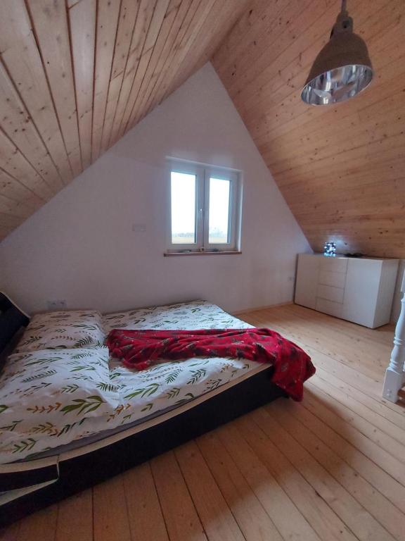 a bedroom with a large bed in a attic at Ranczo pod lasem in Witnica