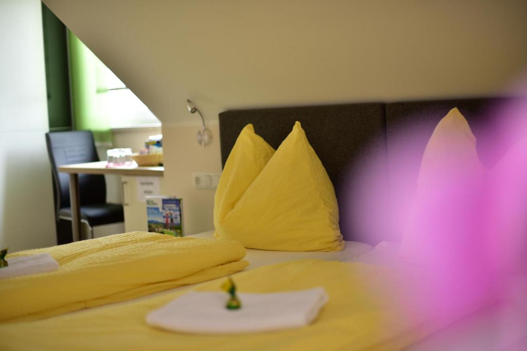 a bedroom with two beds with yellow and pink at Ferienwohnungen und Zimmer Yassi in Spielberg