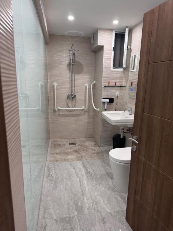 a bathroom with a shower and a toilet and a sink at La Bella Guesthouse in St. Julianʼs