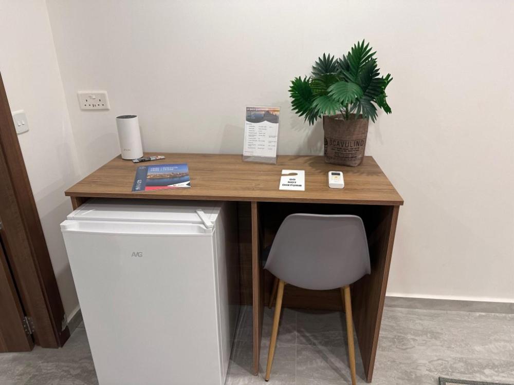 a desk with a potted plant and a chair at La Bella Guesthouse in St. Julianʼs