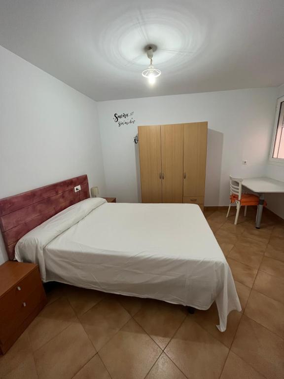 een slaapkamer met een groot wit bed en een bureau bij Apartamento Arrabal in Teruel