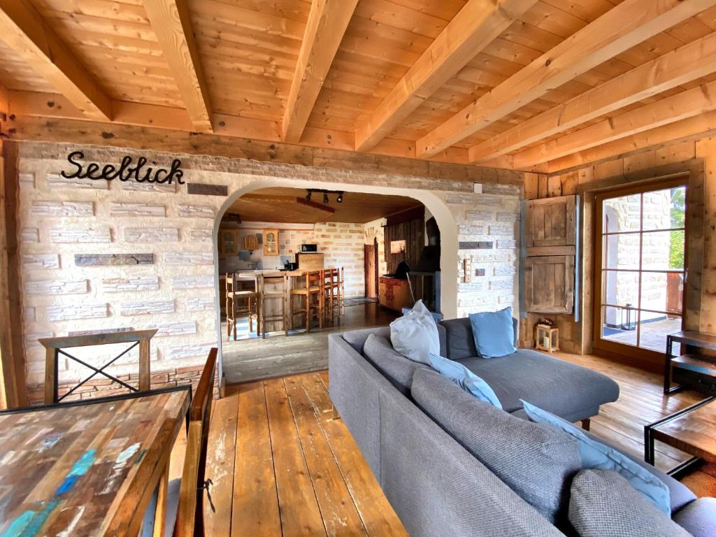 a living room with a couch and a stone wall at Ferienwohnung Seeblick Nr 2 5-Zimmerwohnung - Feldberg Bärental in Feldberg