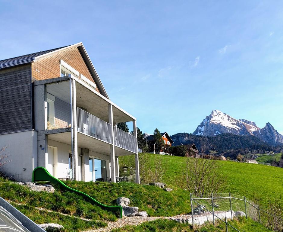 a house on a hill with a mountain in the background at Studio Bijou in Unterwasser