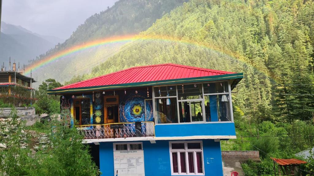 a rainbow over a building with a rainbow at Formosa Hostel & Cafe in Kasol