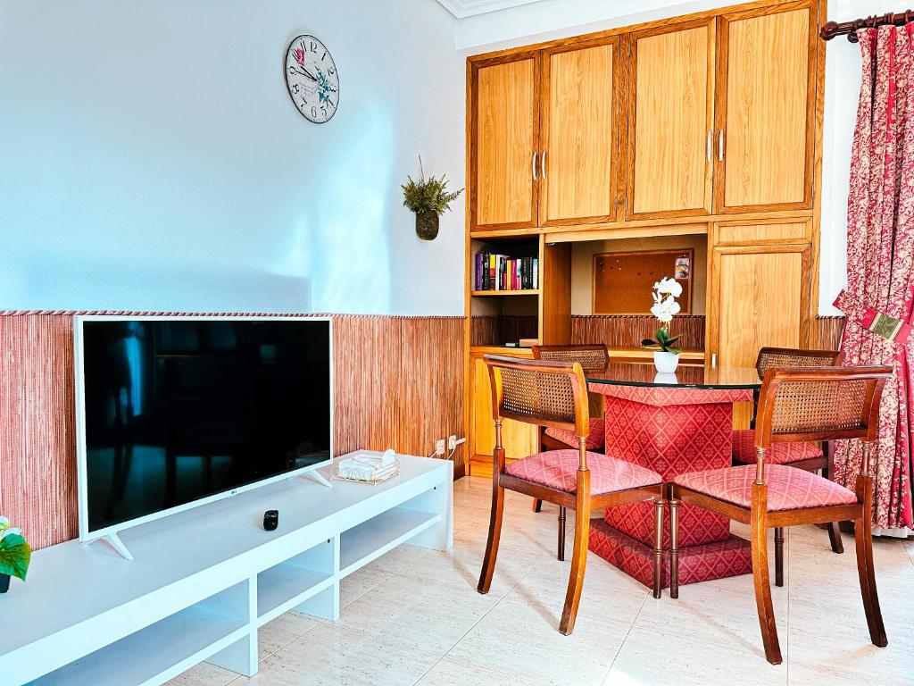 - un salon avec une table, des chaises et une télévision dans l'établissement Apartamento Samil Primera Línea de Playa 3A, à Vigo