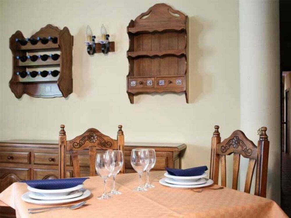 una mesa con sillas y copas de vino. en LA POSADA DEL HORNO en Valdecuenca