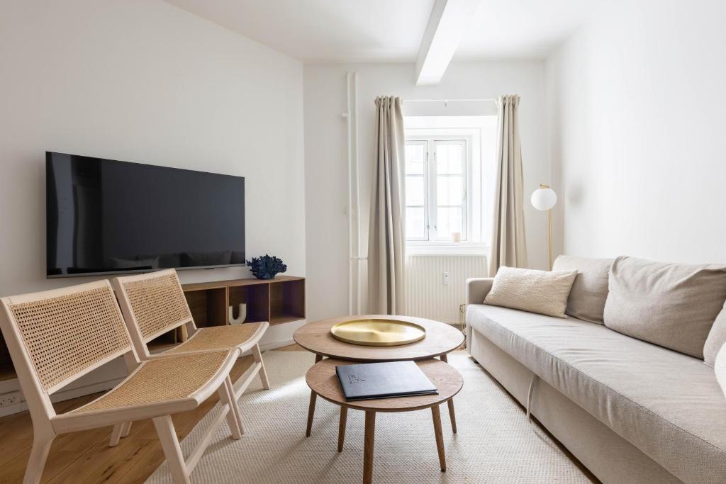 コペンハーゲンにあるStylish 3-BR Flats in CPH Cityのリビングルーム(ソファ、椅子、テレビ付)