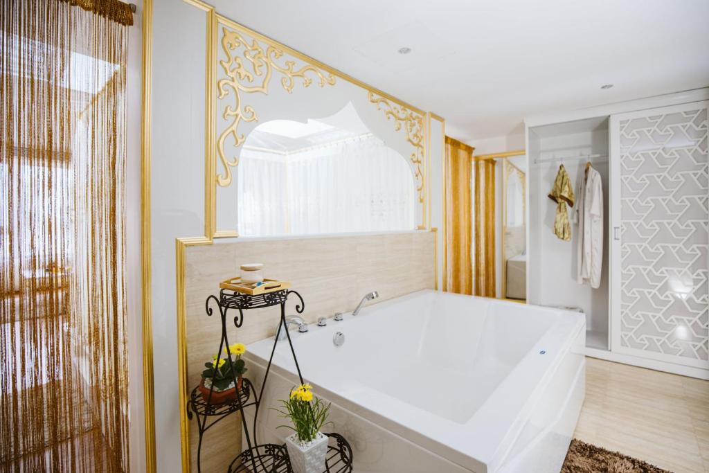 ein großes Bad mit einer Badewanne und einem Fenster in der Unterkunft TND Hotel in Nha Trang