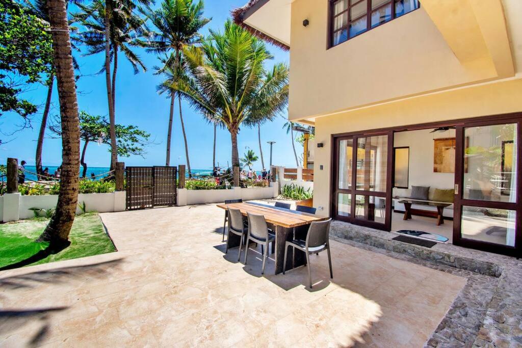 uma casa com um pátio com uma mesa e cadeiras em Hey Jude Bulabog Beachfront Residence em Boracay