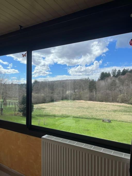 une vue d'un champ depuis une fenêtre dans l'établissement Jolie maison de campagne, à Les Martys