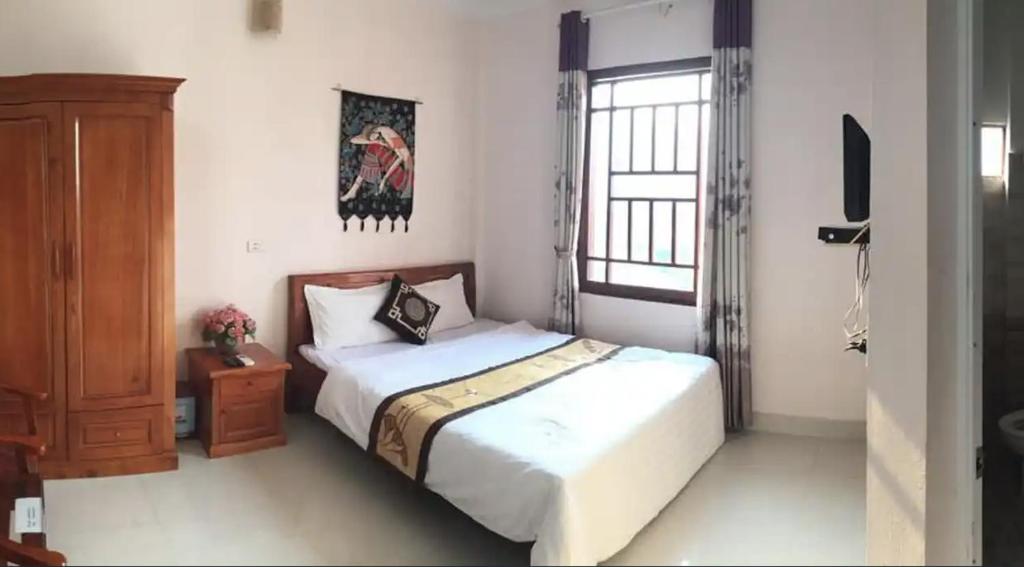ein Schlafzimmer mit einem Bett, einer Kommode und einem Fenster in der Unterkunft Bình Minh hotel in Mai Châu