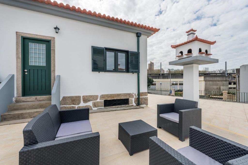 a patio with two chairs and a table and a building at GuestReady - Spacious modern stay in Porto in Vila Nova de Gaia