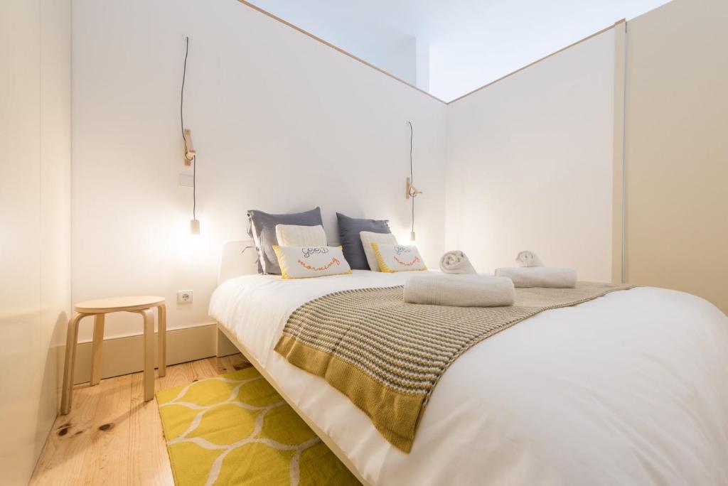 1 dormitorio con 1 cama grande y paredes blancas en GuestReady - Urban oasis with private balcony, en Oporto