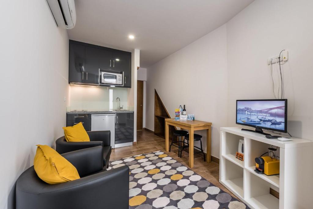 a living room with two chairs and a flat screen tv at GuestReady - Pocket-sized gem in Porto in Porto