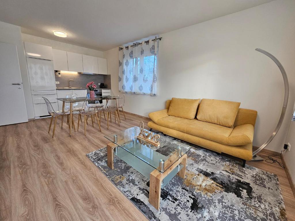 a living room with a couch and a table at Modernes Apartment mit Balkon nahe Stadion und Wörthersee in Klagenfurt