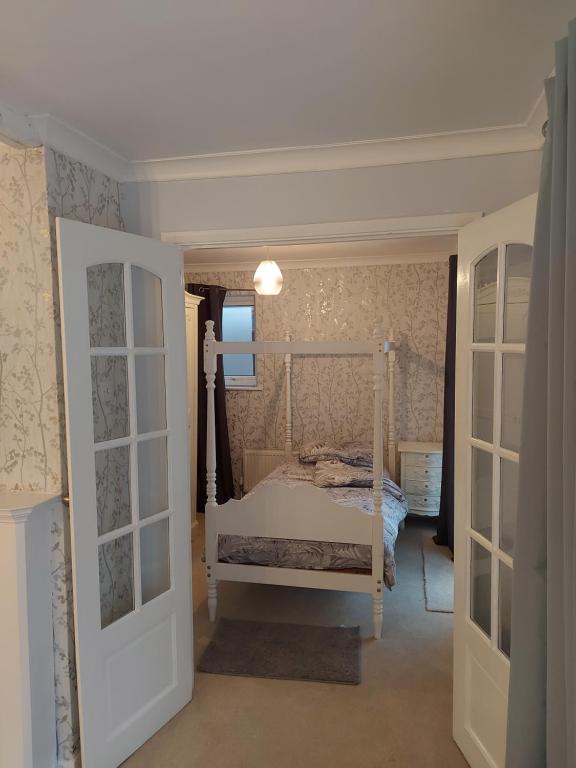 een slaapkamer met een wit bed in een kamer bij The family room at the bungalow in Willesborough