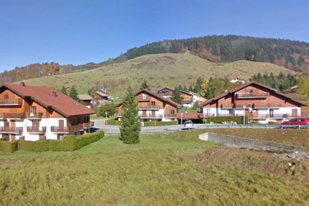 a group of houses with a mountain in the background at Appartement plein sud montagne et lacs in Habère-Poche
