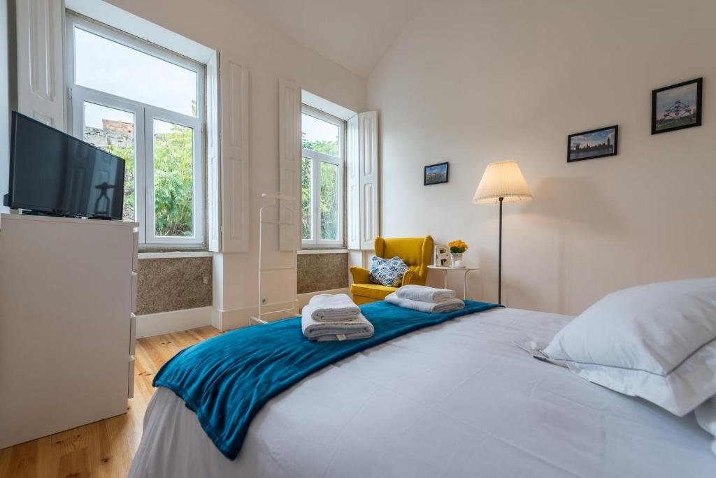 een slaapkamer met een groot bed en een flatscreen-tv bij GuestReady - Quaint comfort near Clérigos Tower in Porto