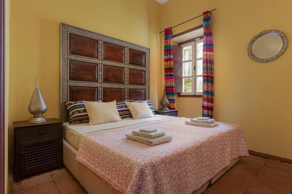 a bedroom with a large bed with towels on it at Casa da Moura in Lagos