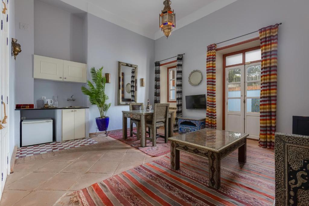 a living room with a table and a kitchen at Casa da Moura in Lagos