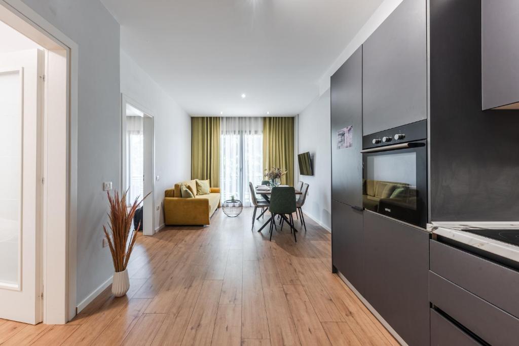 uma sala de estar com uma cozinha e uma sala de jantar em Modern Central Apartment em Durrës