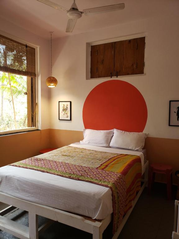 a bedroom with a large bed with a red headboard at Laxmi Happy Home in Querim Goa in Querim
