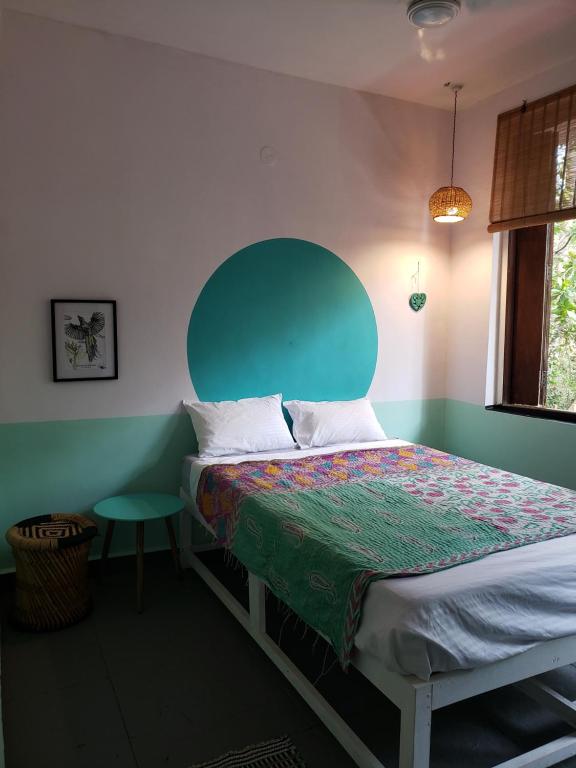 a bedroom with a bed with a green headboard at Laxmi Happy Home in Querim Goa in Querim
