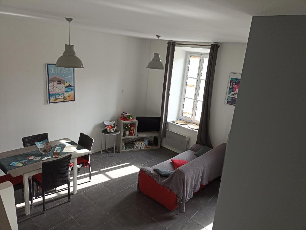 グリュイッサンにあるJolie Maison au centre du villageのリビングルーム(テーブル、ソファ付)、ダイニングルーム