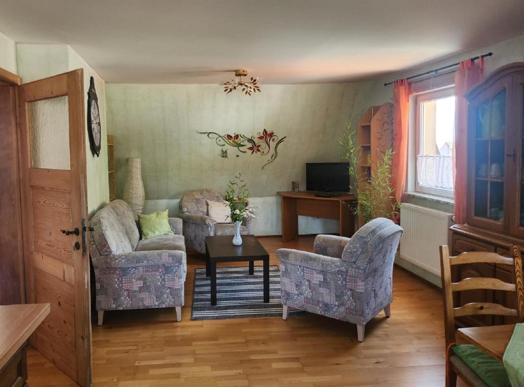 a living room with two chairs and a table at Ferienwohnung Langhammer in Schonungen
