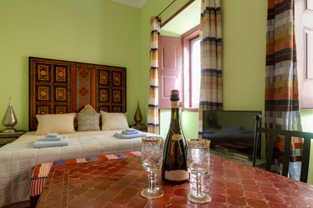 a bedroom with a bed and a bottle of wine on a table at Casa da Moura in Lagos