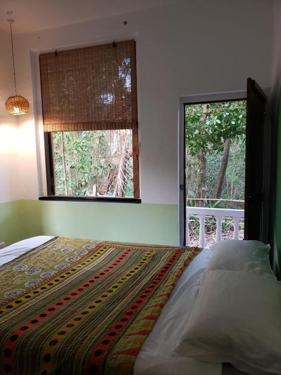 a bedroom with a bed and a large window at Laxmi Happy Home in Querim Goa in Querim